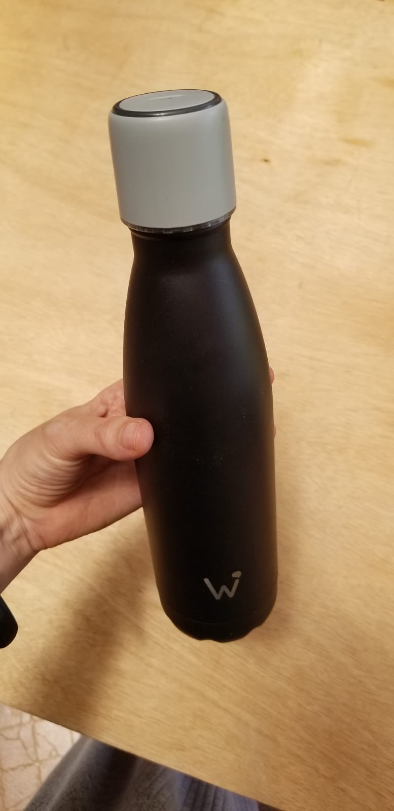 Hand holding the water.io smart water bottle