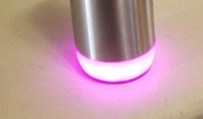 HydrateSpark Pro smart water bottle with base glowing fuchsia after taking a drink