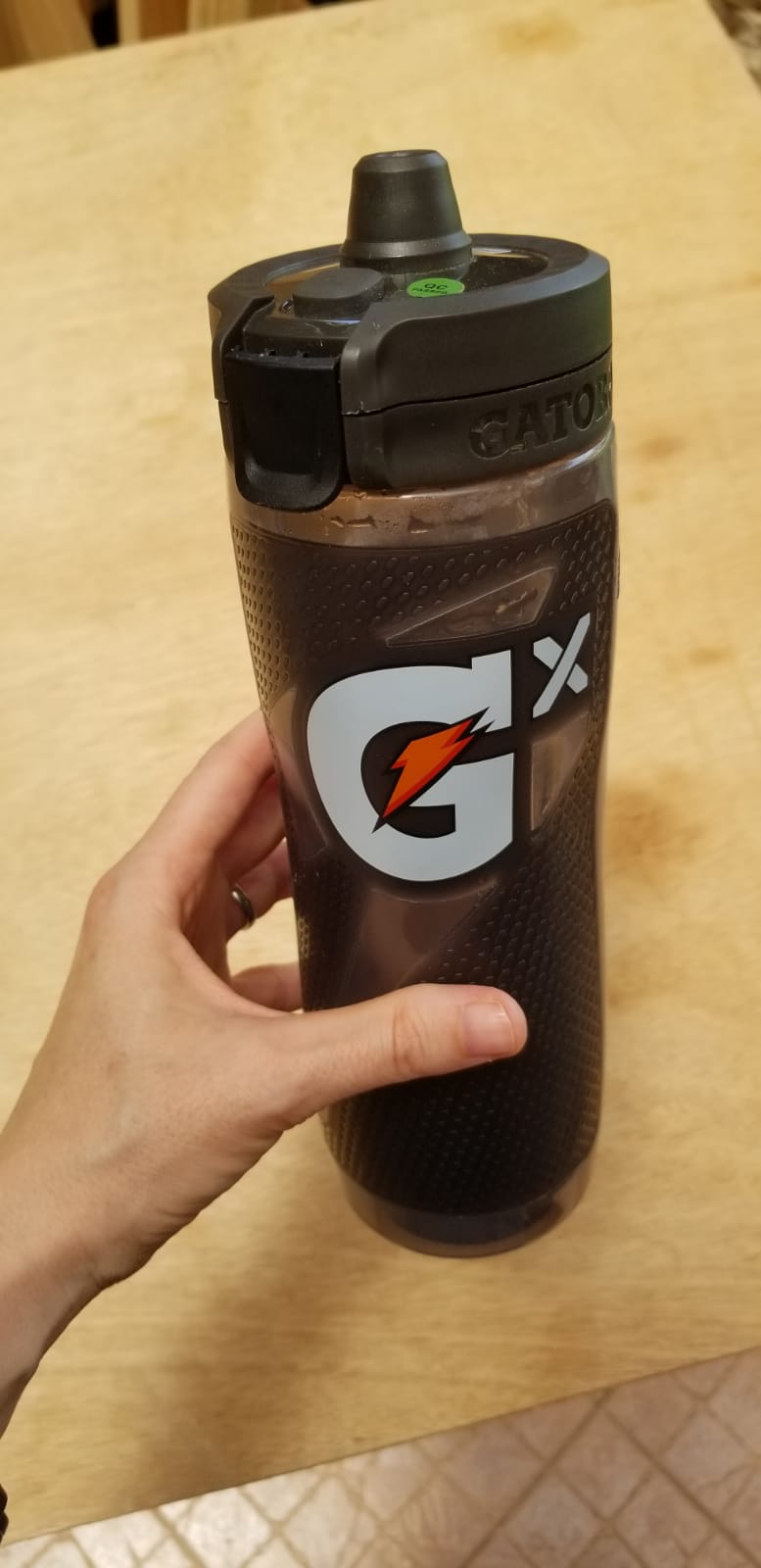 Hand holding Gatorade Smart Gx water bottle